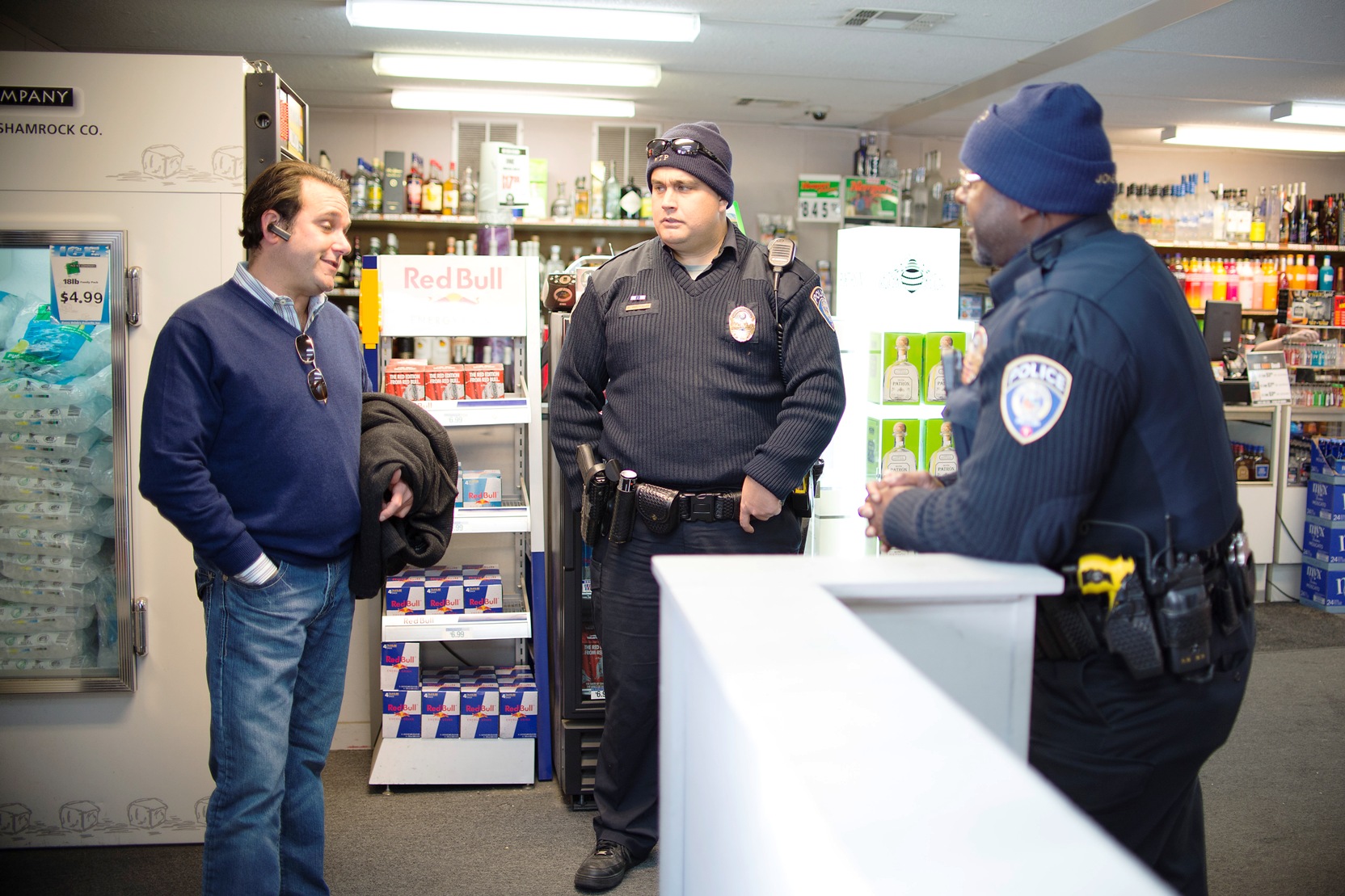 Metro Transit police officers David Hutchinson and Sidney Jones talk with Dean Rose, who owns Broadway Liqour Store at the corner of Broadway and Penn avenues.