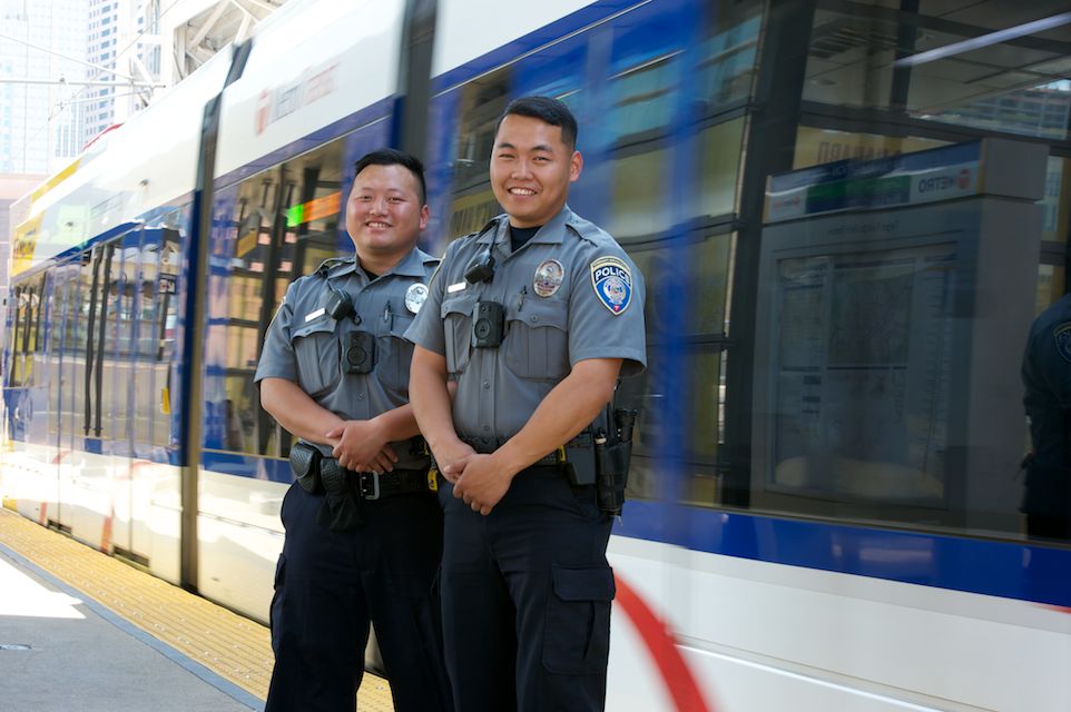 Community Service Officers stand outside a METRO line train