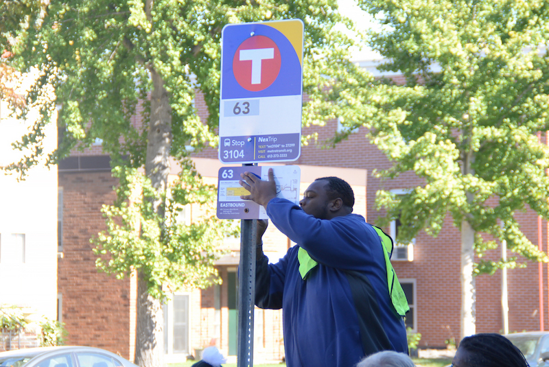 Man installing a bus stop sign