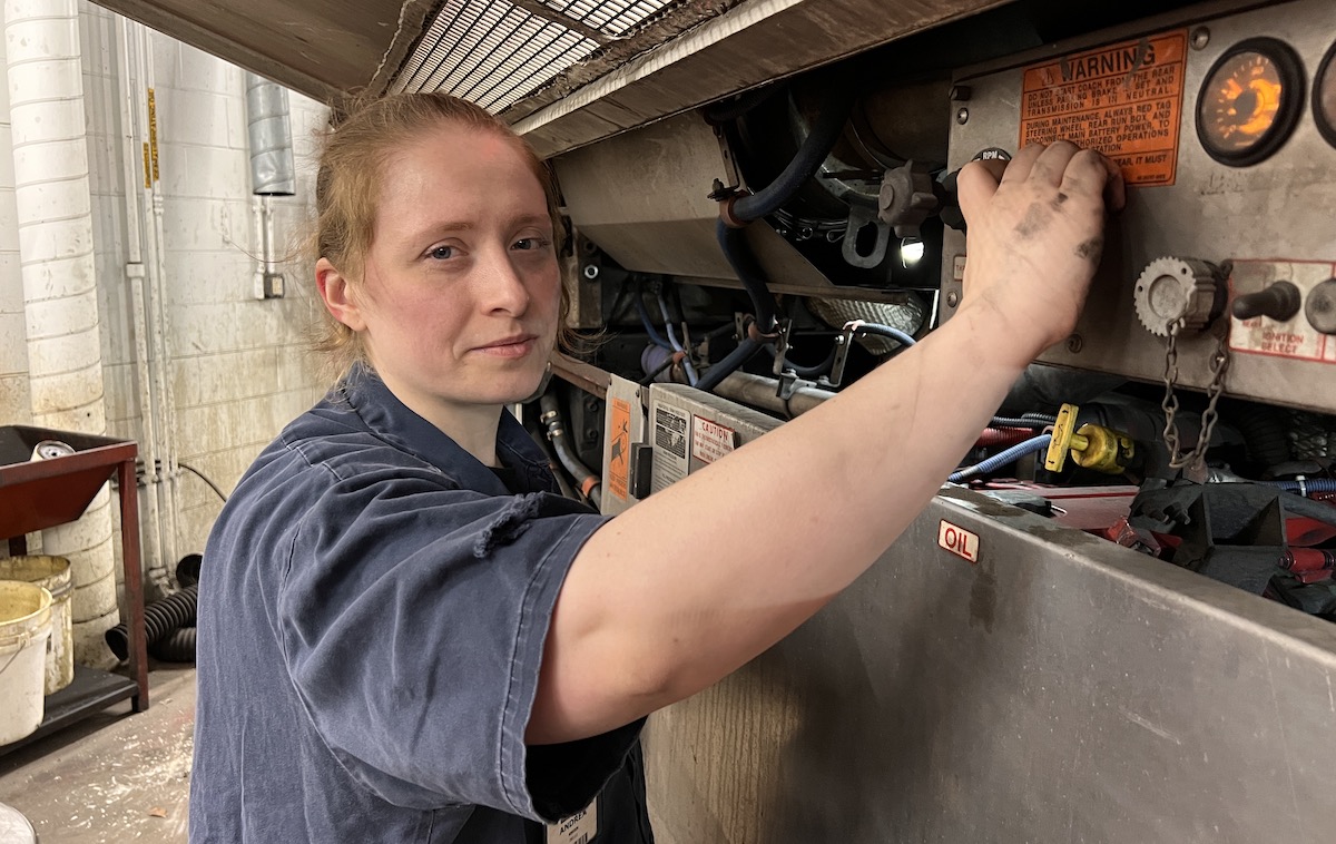 Portrait of a female technician working on a bus.