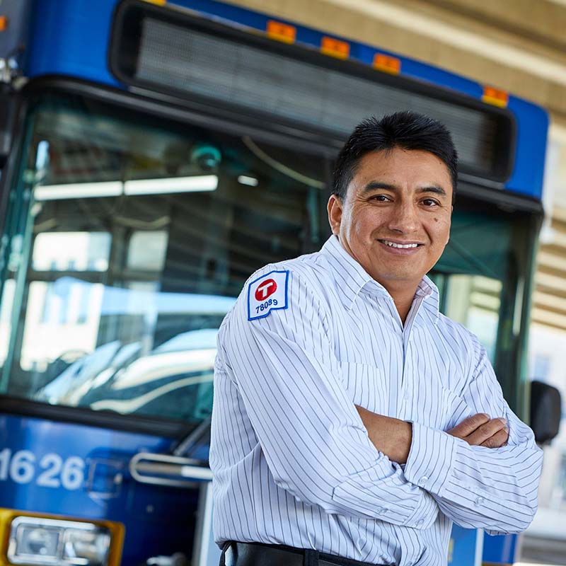 Bus driver standing in front of bus