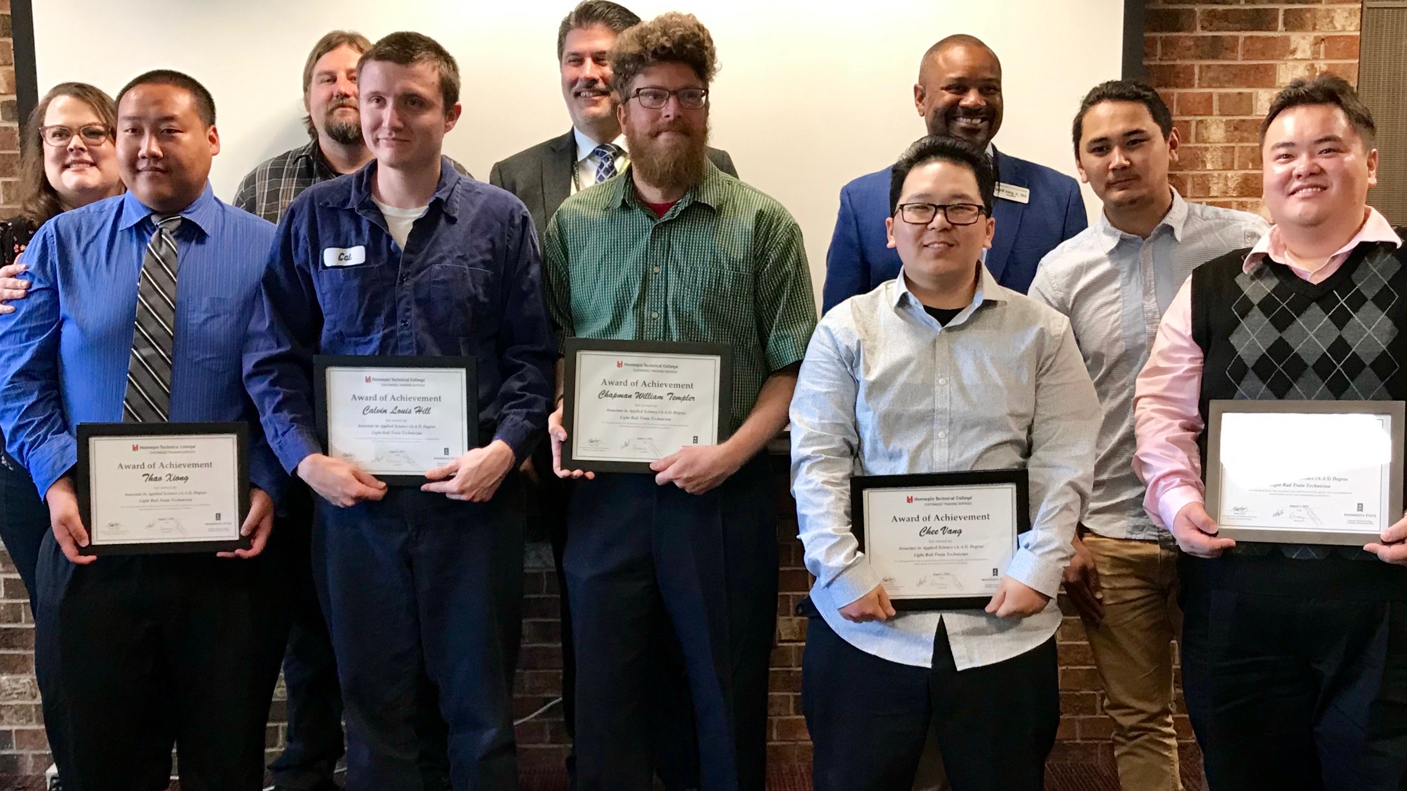 Six LRT train technicians receive certificates of completion in a ceremony Aug. 2, 2019, at Hennepin Technical College where they earned associate degrees. From the left in the front row, they are: Thao Xiong, Calvin Hill, Chapman Templer, Chee Vang, Tenzin Kunga and Toua Yang.