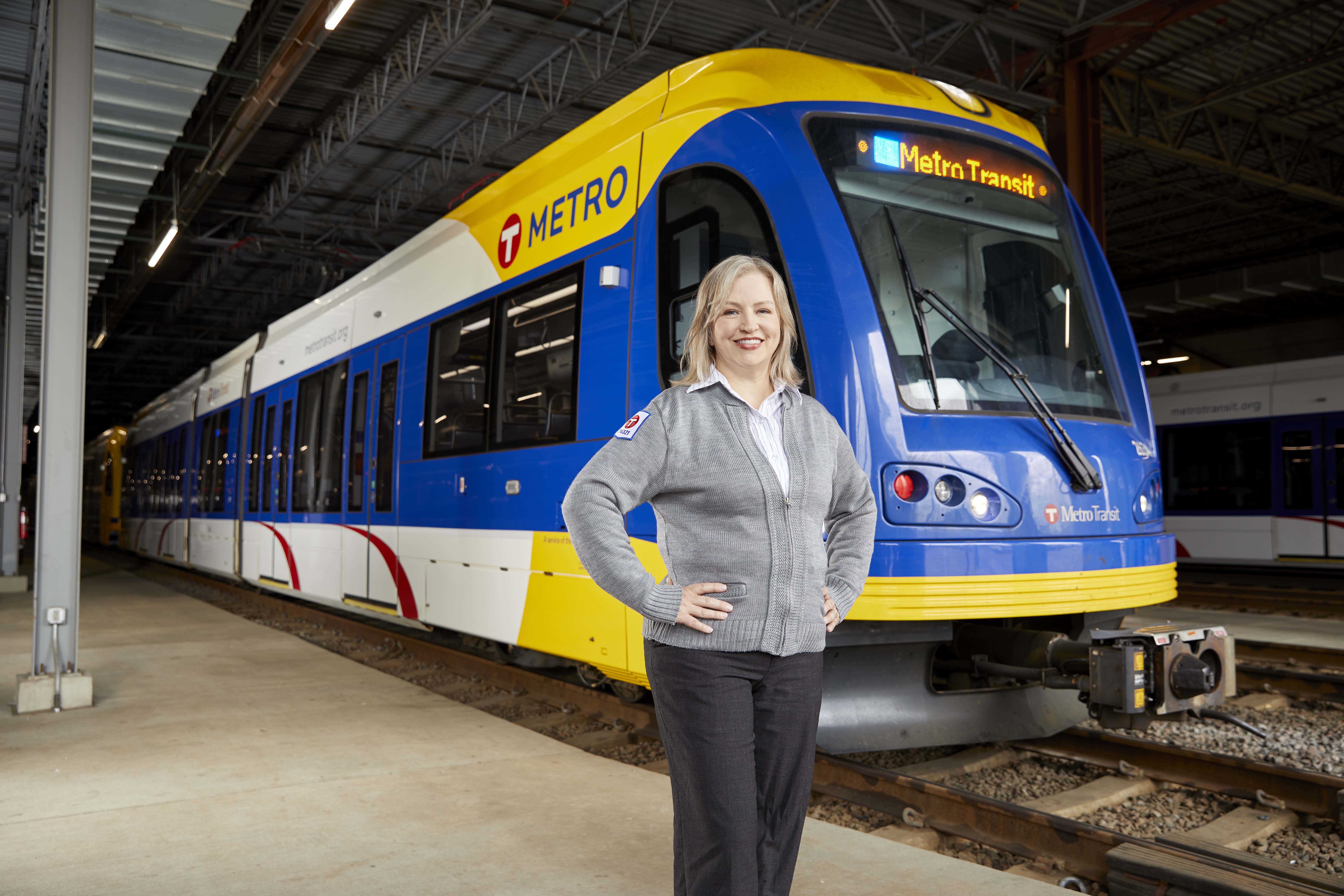 Train Operator Beth de Salguero standing in front of a light rail vehicle.