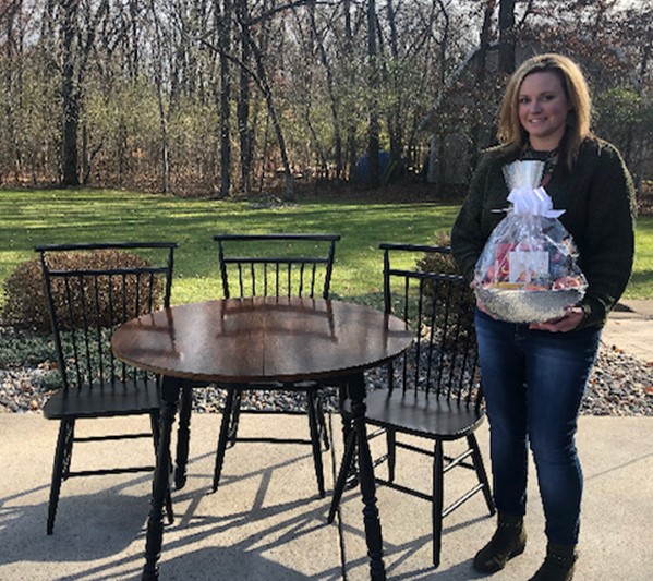 Lt. Erin Dietz with refinished furniture and a gift basket.