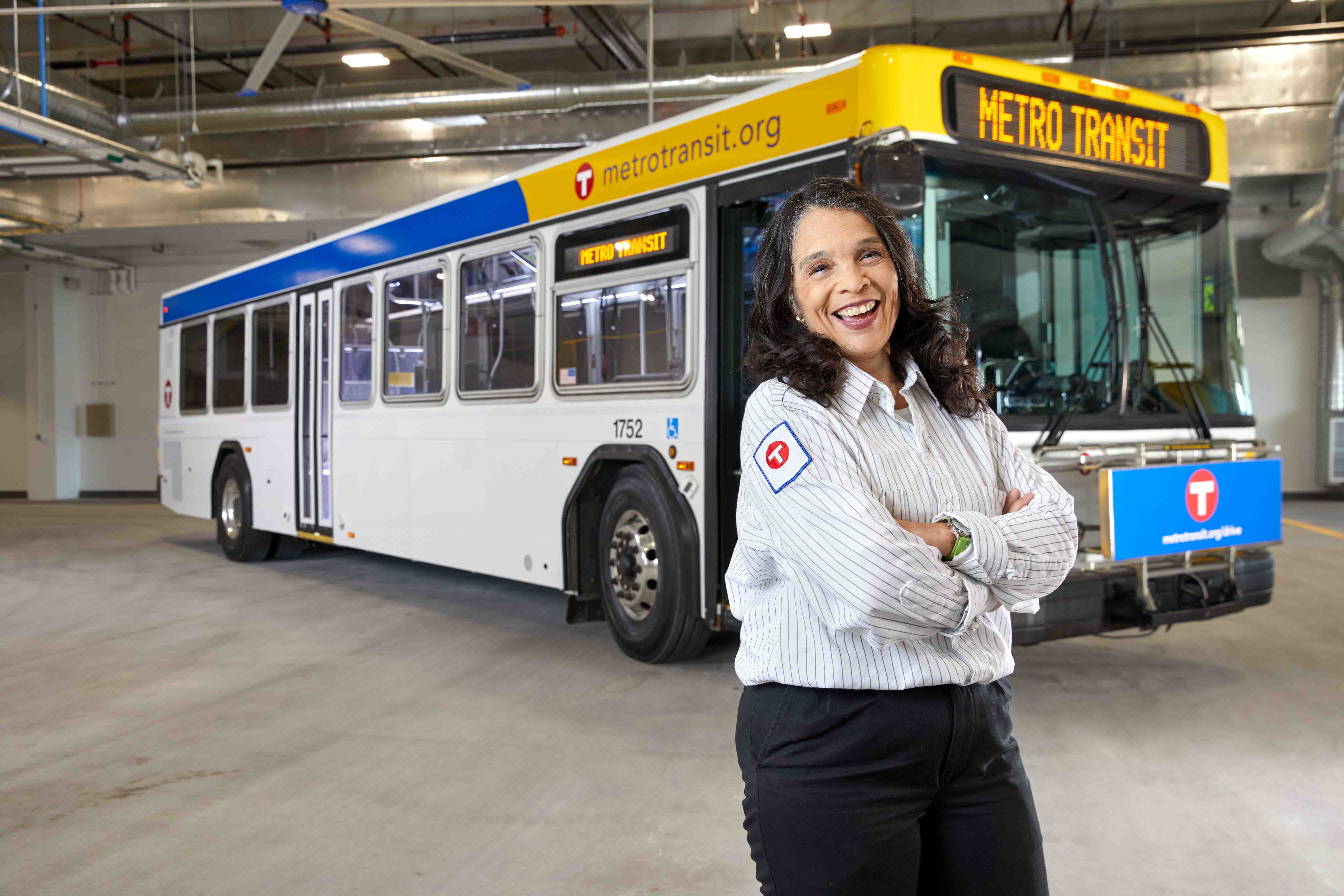 Bus Operator Maria Flores standing in front of a bus. 