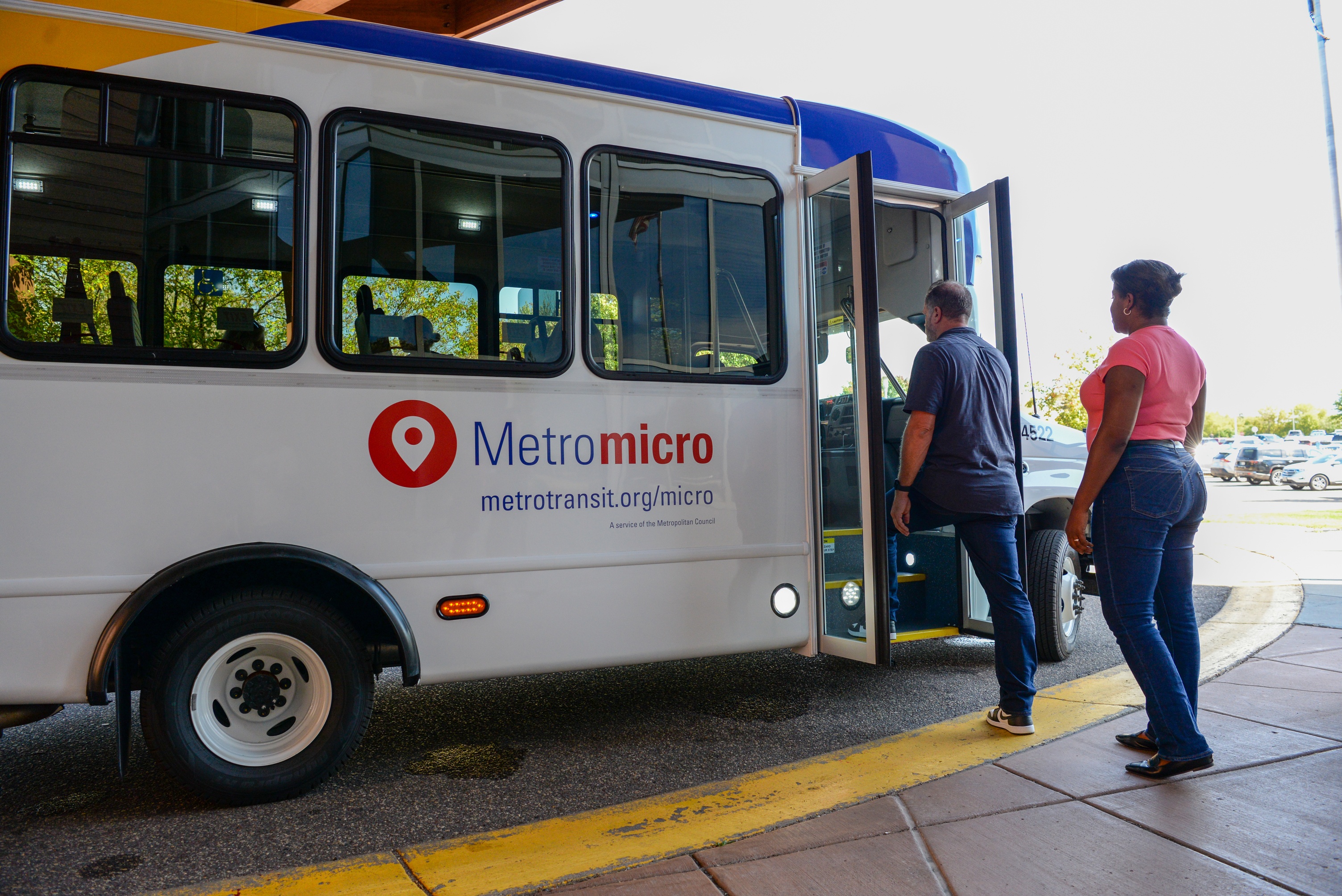 Riders board a Metro micro bus. Riders board a Metro micro bus.