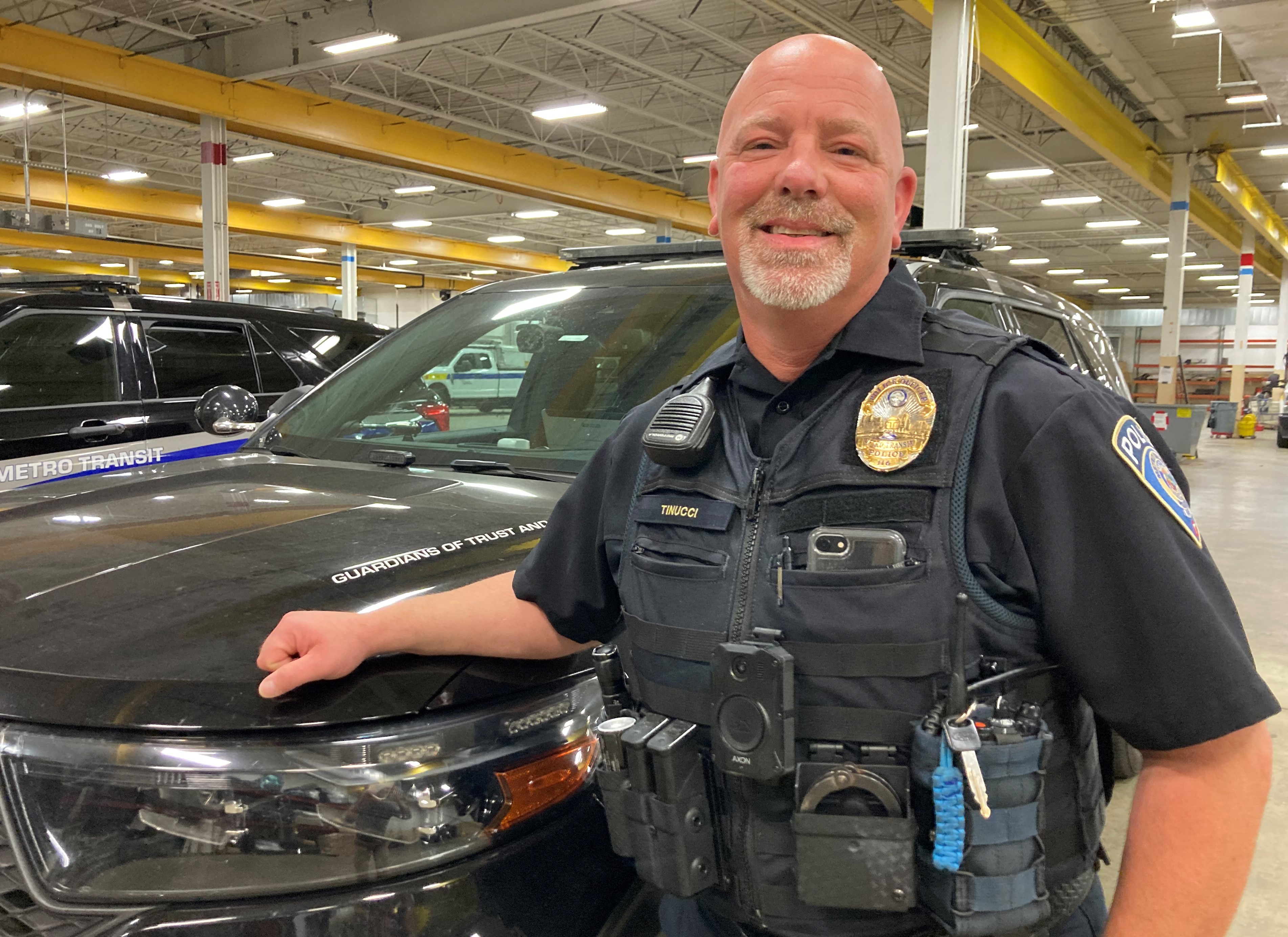 Officer Scott Tinucci stands with his Metro Transit Police Department squad car.