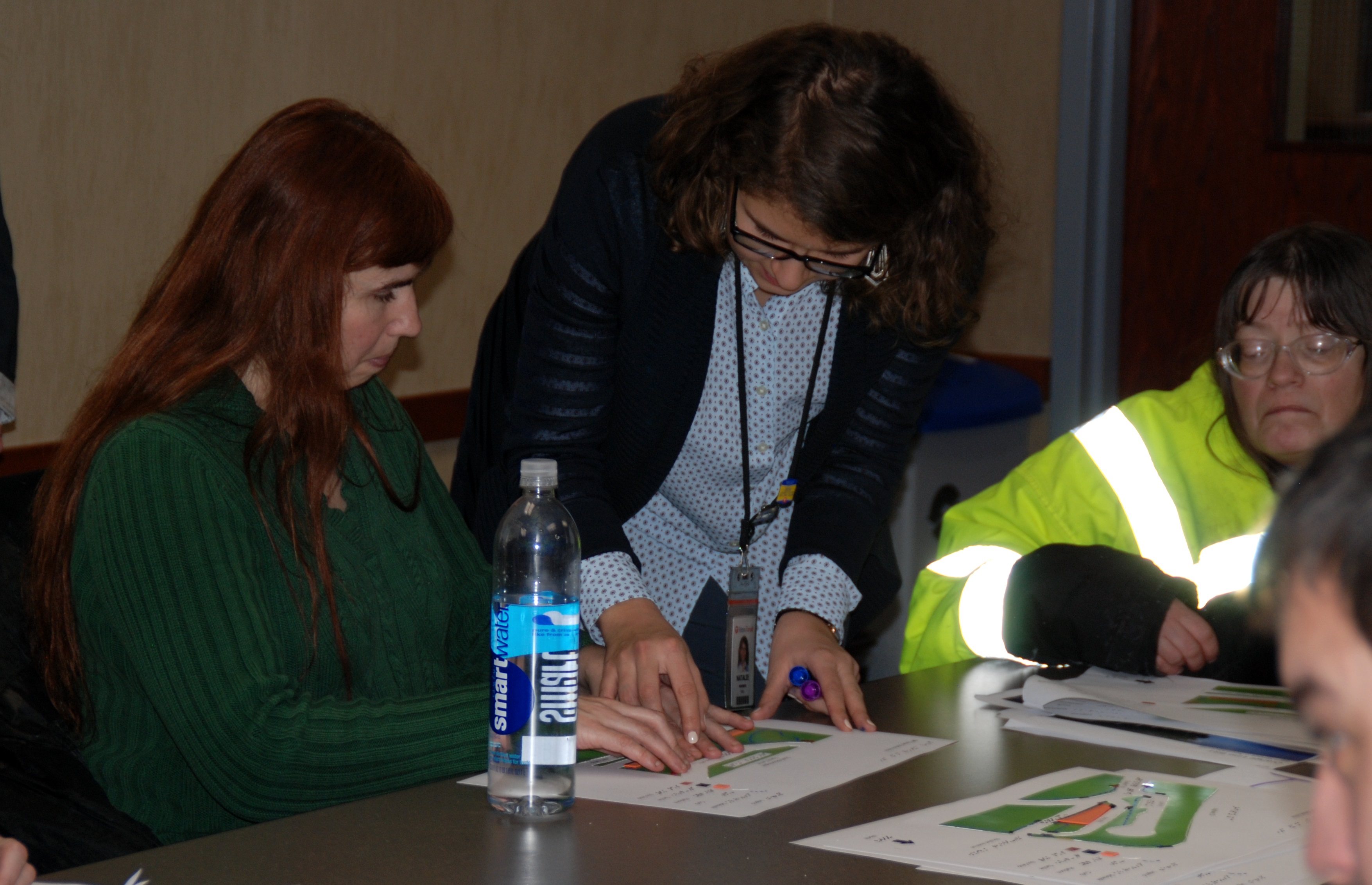 Associate Planner Natalie Westberg directs Transportation Accessibility Advisory Committee Sam Jasmine to station features on a layout printed in braille during a recent station design workshop.
