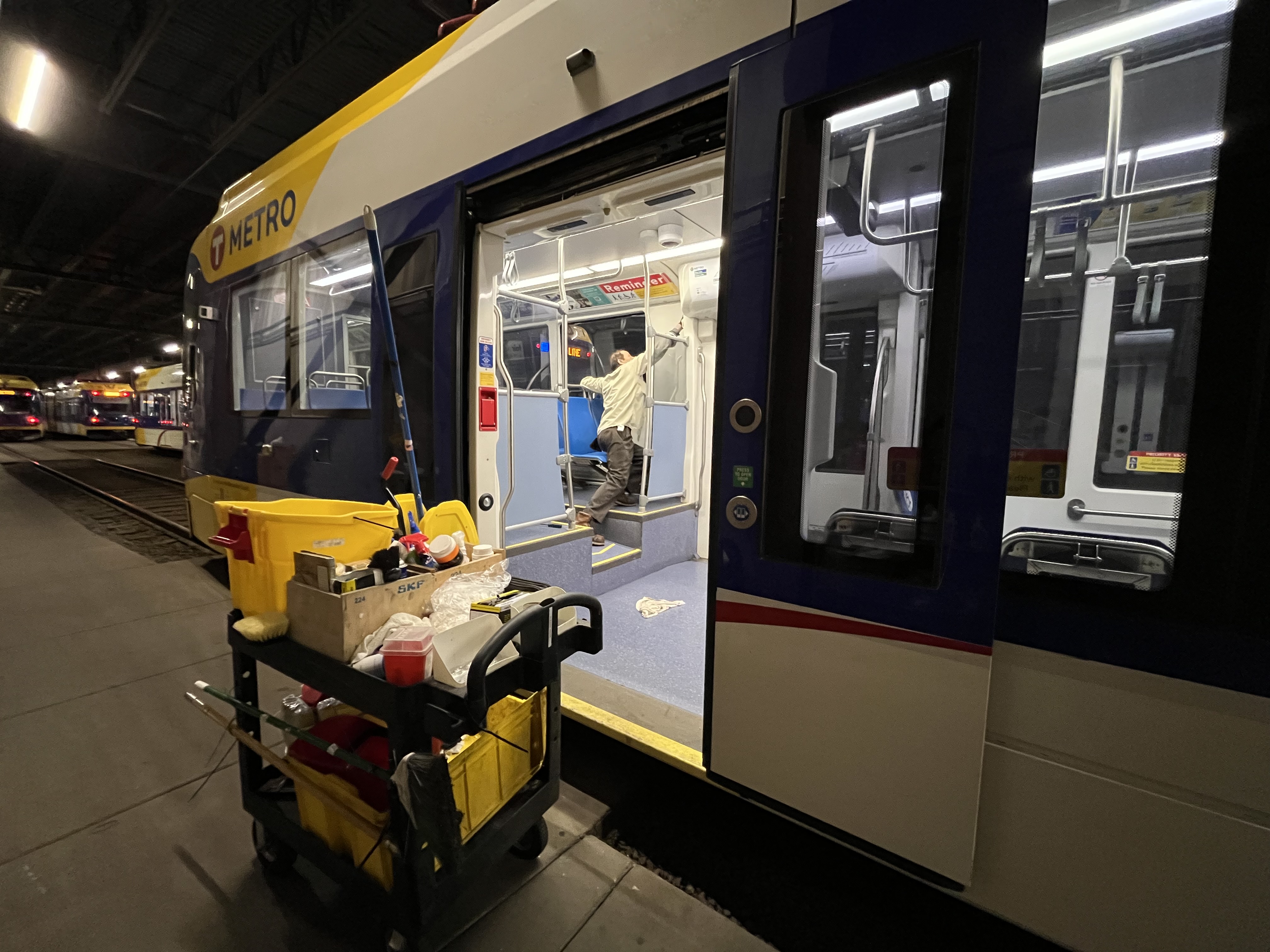 Helper Hassan Raha cleans a light rail vehicle.