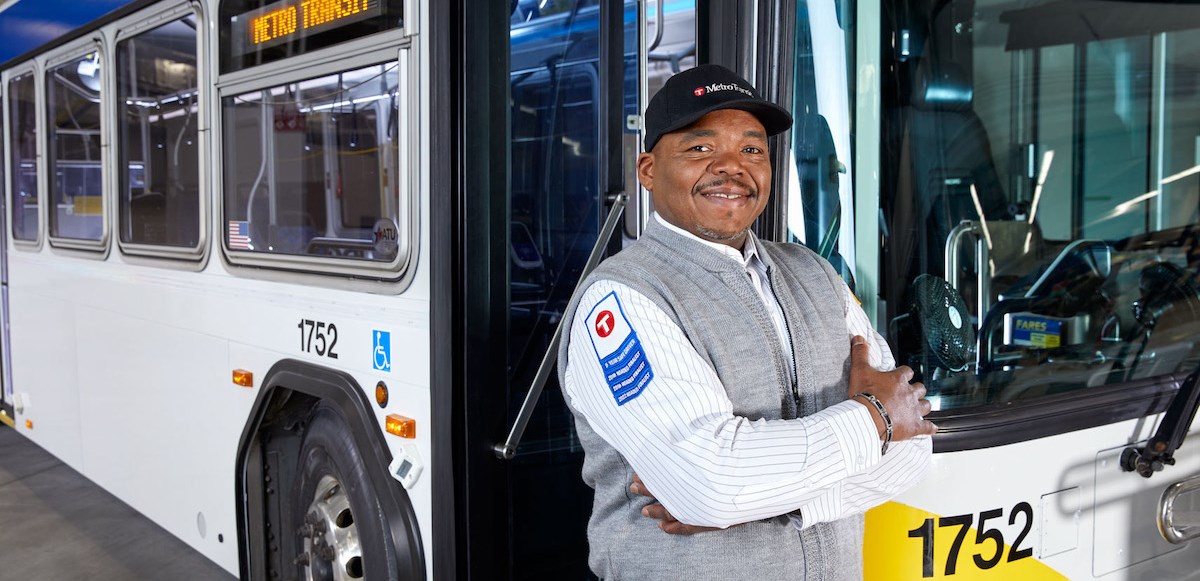Bus Driver sitting in bus smiling. 