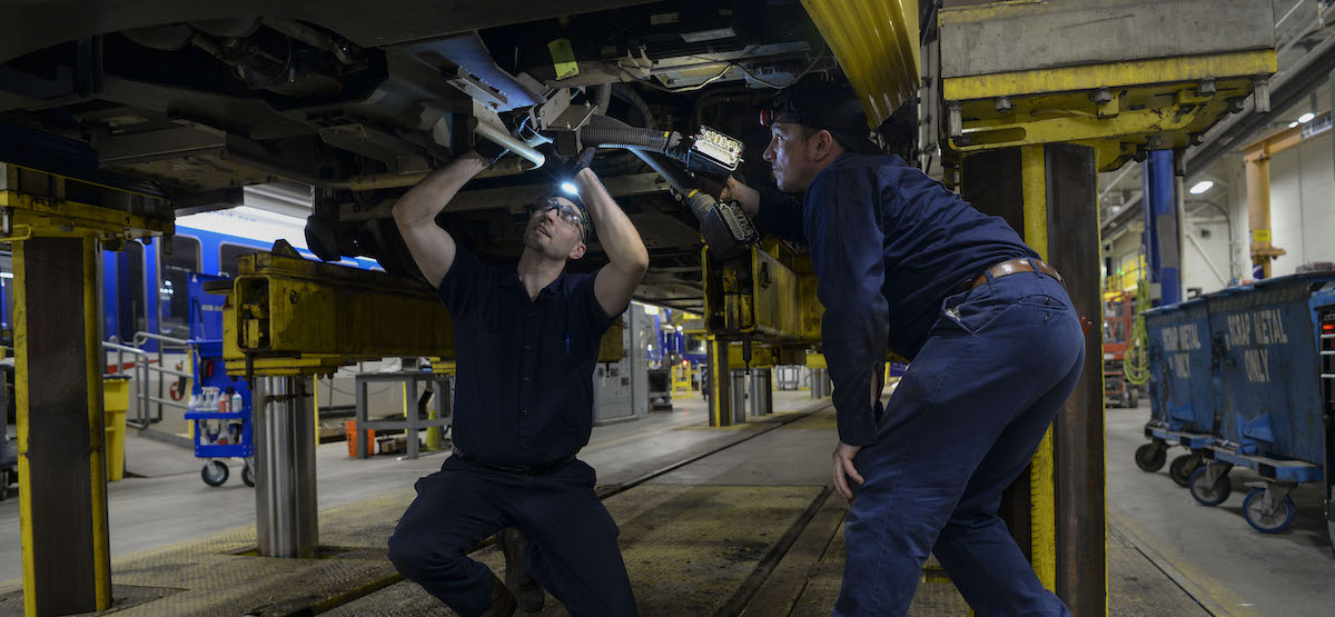 Mechanics working under a bus.