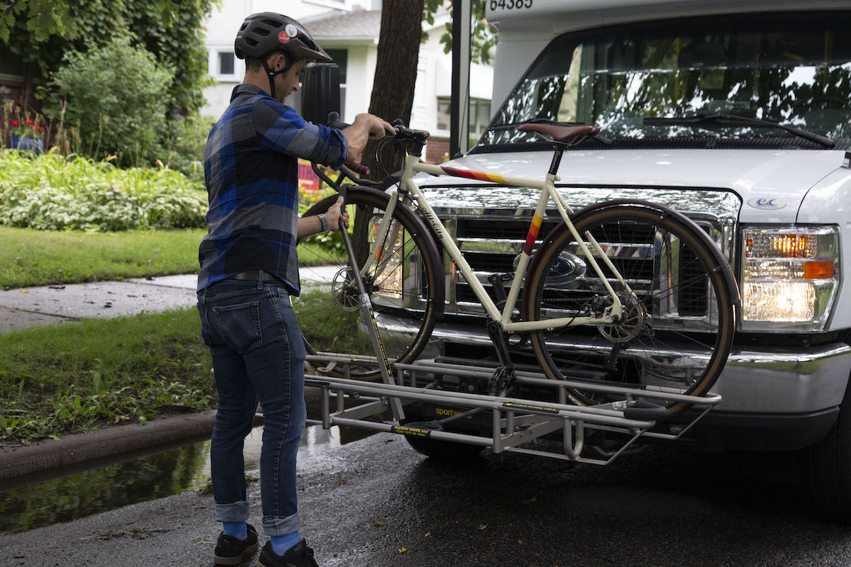 A customer placing a bike on a micro bus rack.