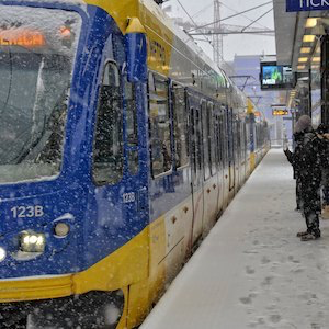 A customer waits at a METRO train station in the snow