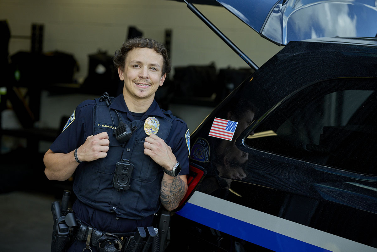 A Transit Police officer next to a squad car