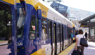 White, blue and yellow light rail car at Government Plaza.