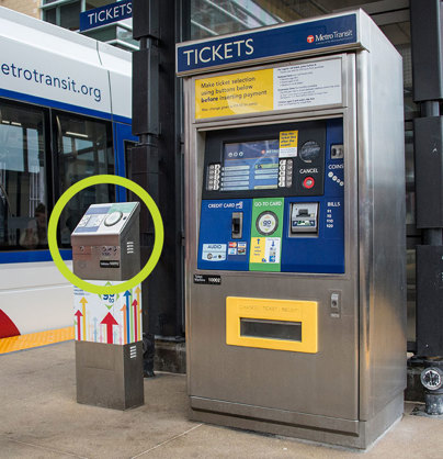 The Go-To Card reader is a stainless steel box located near ticket vending machines or other infrastructure near the platform.
