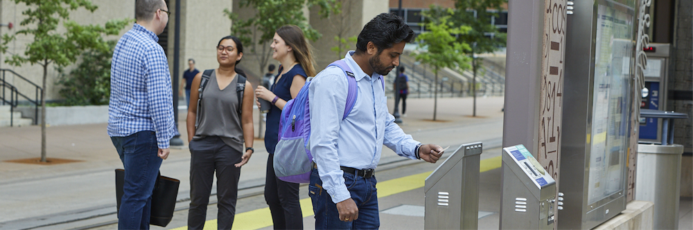 Transit rider purchasing fare at train stop