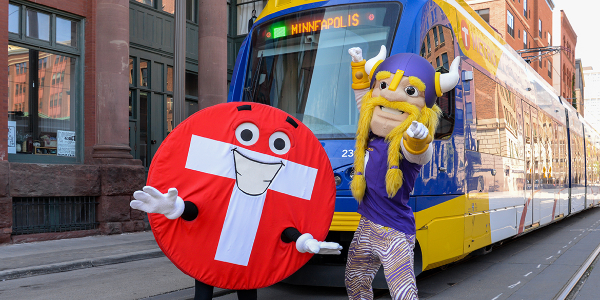 Skip with Vikings mascot in front of Metro Transit Green Line